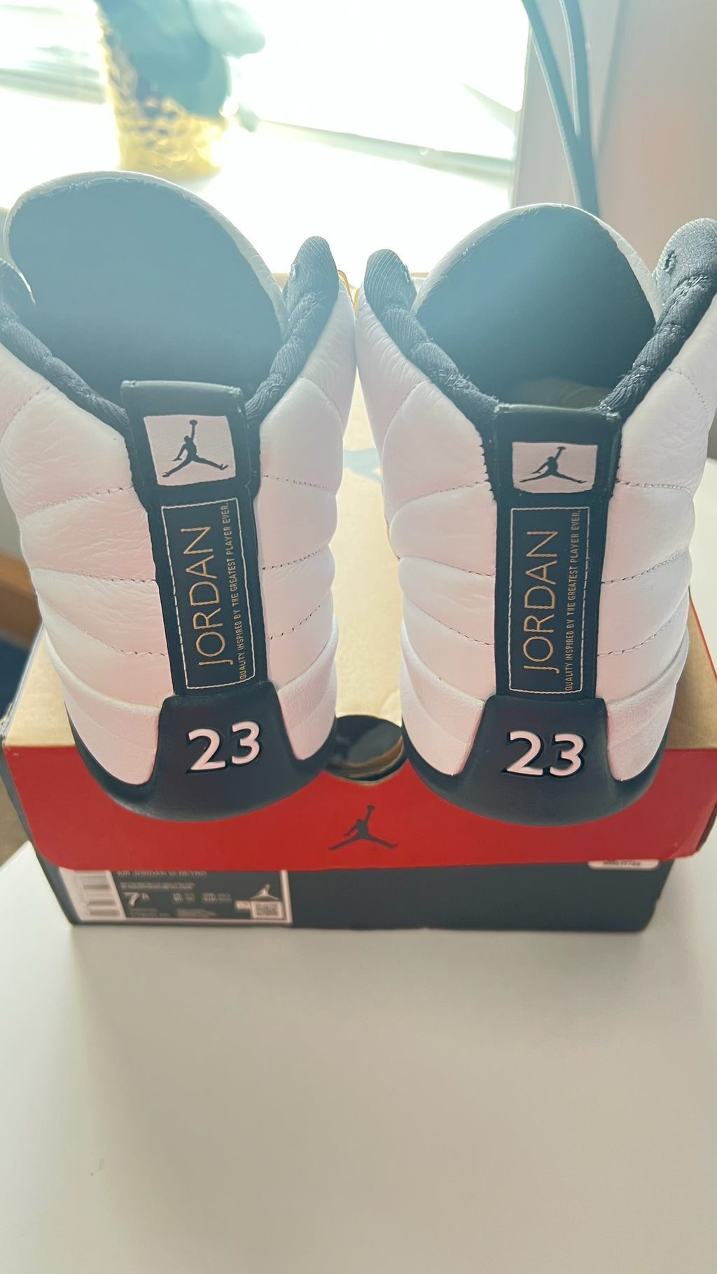 Shop Nova Finds Air Jordan 12 Retro high-top sneakers in white and black with 23 heel detail and Jumpman branding