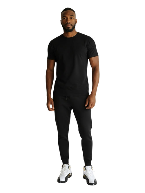 Shop Nova Finds model wearing a black t-shirt and joggers with white and black Air Jordan 12 Retro basketball sneakers
